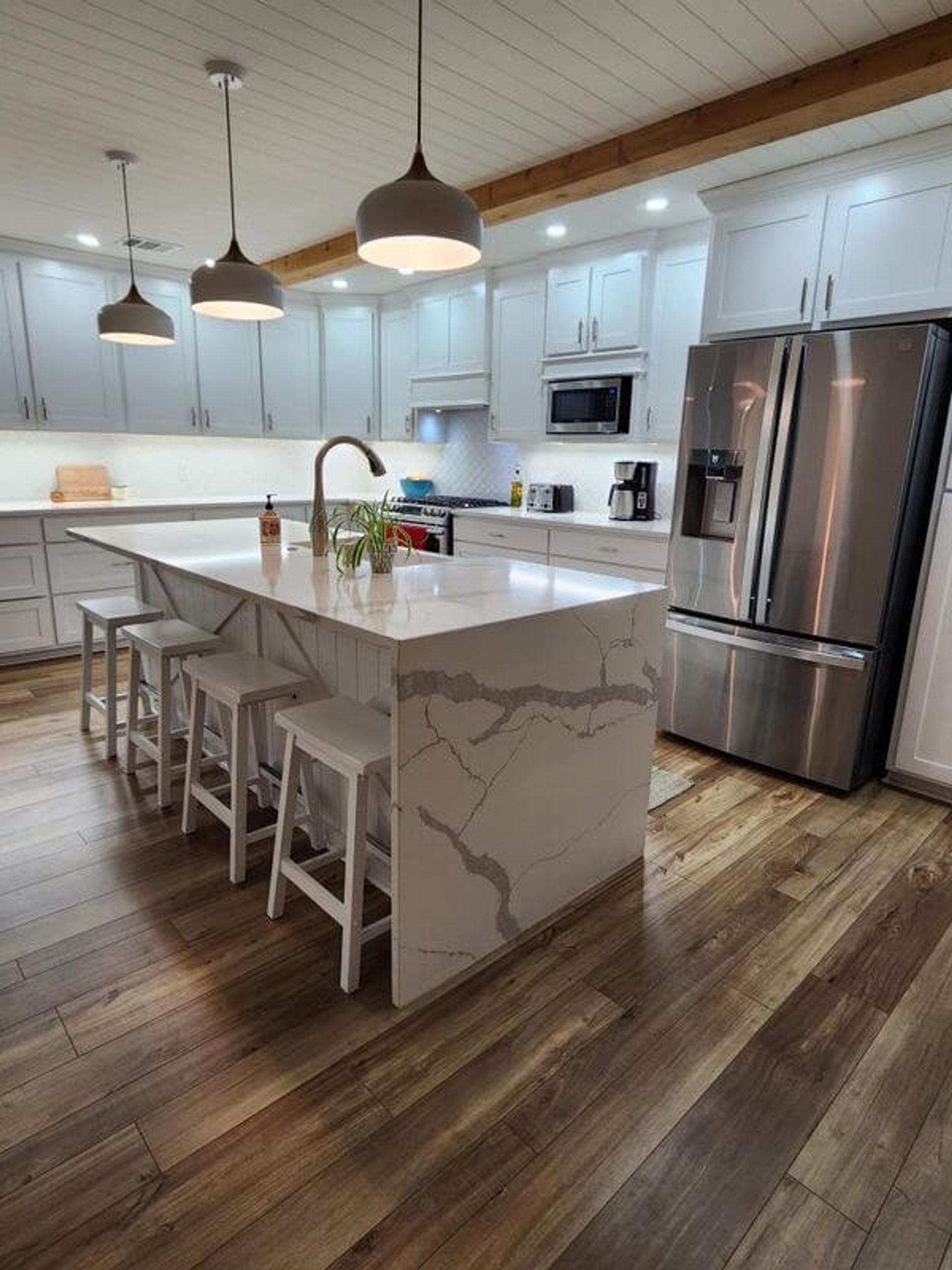 custom kitchen design with wood floors, kitchen island, custom cabinets, and custom lighting